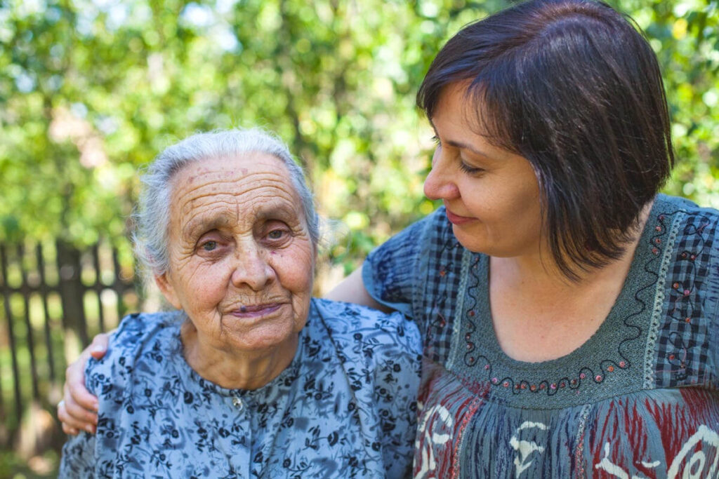Family caregiver and her loved one standing together